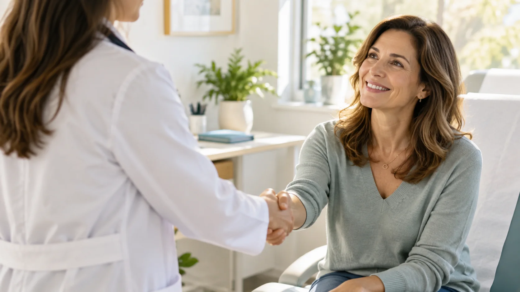 Médica saludando cálidamente a una paciente adulta